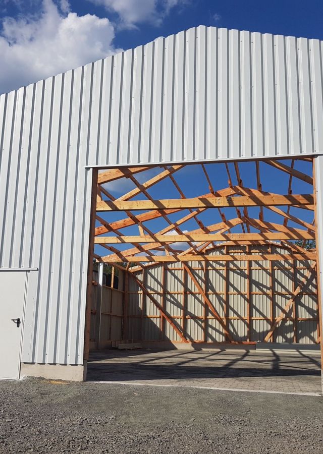 Holzkonstruktion im Rohbau mit Seitentür (Halle im Bau)