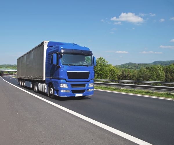 Blauer LKW auf der Autobahn (für Lieferung/Montage)