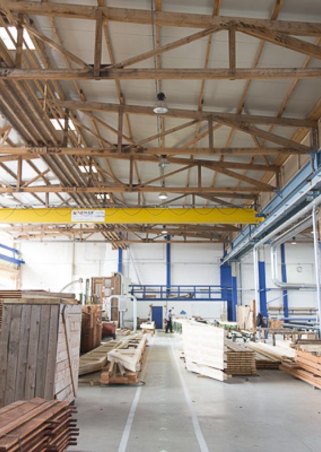 Fertigungshalle mit Holzbinder-Decke und Laufkran (Innenansicht)