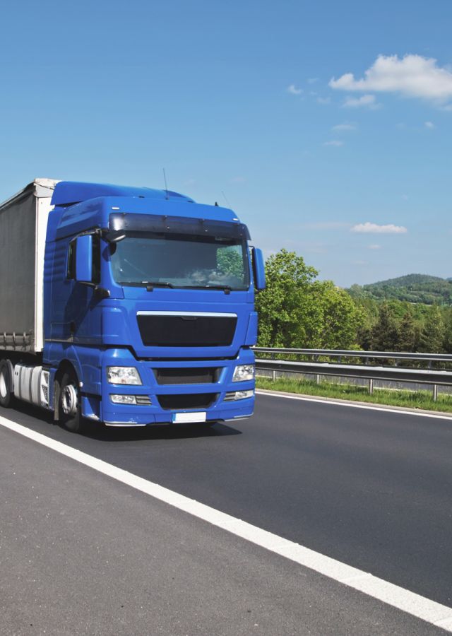 Blauer LKW auf der Autobahn (für Lieferung/Montage)